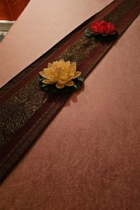 Nahaufnahme der Lotusblumen auf der Massage-Liege bei Thai Life Massage Velbert, die eine beruhigende und entspannende Atmosphäre schaffen.
